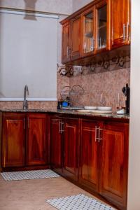 a kitchen with wooden cabinets and a sink at Lucia Homes & Stays in Dodoma +14 photos