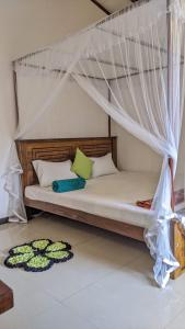 een bed met een hemelbed in een kamer bij The Shilpa Villa in Unawatuna +34 foto's