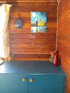 een blauwe kast met een klok aan een houten muur bij Jungle Cabin Leisure Bay in Port Edward +75 foto's