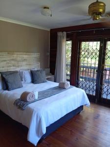 een slaapkamer met een groot wit bed met handdoeken erop bij Jungle Cabin Leisure Bay in Port Edward