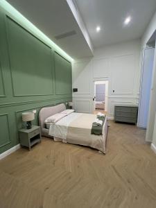 een slaapkamer met een bed en een groene muur bij Palazzo Ducale in Salerno