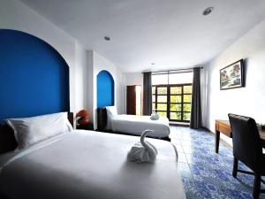 une chambre d'hôtel avec deux lits et un cygne assis sur un banc dans l'établissement The Moon Rabbit Resort Pai, à Pai