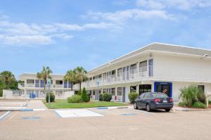 un'auto parcheggiata in un parcheggio di fronte a un edificio di Motel 6 Gulfport, MS Airport a Gulfport