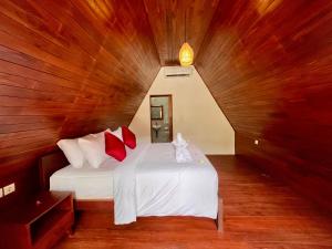een slaapkamer met een wit bed met rode kussens bij Dalung Tropical in Dalung