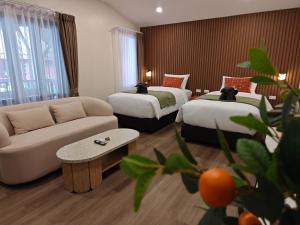 a hotel room with two beds and a couch at Tangerine Villa Patong in Patong Beach +22 photos