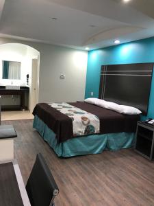 een slaapkamer met een bed en een blauwe muur bij Americas Best Value Inn & Suites Spring / N. Houston in Spring
