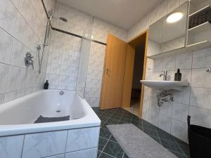 a bathroom with a bath tub and a sink at Ferienwohnung Aischgrund 75qm Nähe Nürnberg Bamberg Steigerwald in Lonnerstadt