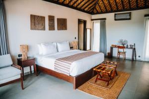 een slaapkamer met een bed, een stoel en een tafel bij Menjaga Bay in Labuan Bajo +104 foto's
