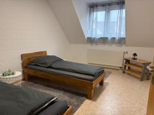 a bedroom with two beds and a window at Ferienwohnung Aischgrund 75qm Nähe Nürnberg Bamberg Steigerwald in Lonnerstadt