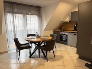 a kitchen with a table and chairs in a room at Ferienwohnung Aischgrund 75qm Nähe Nürnberg Bamberg Steigerwald in Lonnerstadt +11 photos