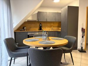 a kitchen with a wooden table and chairs in a room at Ferienwohnung Aischgrund 75qm Nähe Nürnberg Bamberg Steigerwald in Lonnerstadt