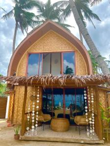a small house with a large window and palm trees at The Sanctuary in El Nido