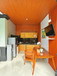 a kitchen with a wooden ceiling and a wooden table at Ubud Suarga Private Pool Villa in Ubud