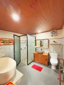 een badkamer met een bad, een toilet en een wastafel bij Ubud Suarga Private Pool Villa in Ubud +41 foto's
