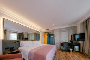 een hotelkamer met een bed en een televisie bij Moenia Boutique Hotel in Durrës