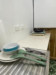 een stapel keukengerei bovenop een koelkast bij Albany house in Motungarara