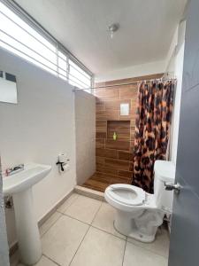 een badkamer met een toilet, een wastafel en een douche bij Noir Beach Suite in Ciudad Madero +2 foto's