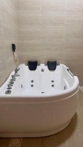 een wit bad met 2 stoelen in een badkamer bij Riva chalet in Badīyah