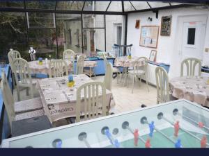 a patio with tables and chairs and a swimming pool at Thatched 2persons Cottage in Currahy Bridge