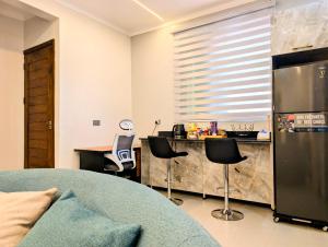 Il comprend une cuisine équipée d'un comptoir avec des chaises et d'un réfrigérateur. dans l'établissement Hakuna Matata Apartment in Munyonyo, à Kampala