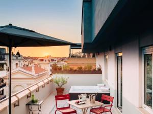 a balcony with a table and chairs and an umbrella at Hotel Mercure Roma Corso Trieste in Rome