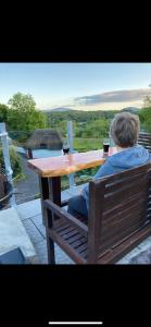 a man sitting at a table with two glasses of wine at Thatched 2persons Cottage in Currahy Bridge +11 photos