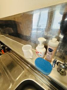 eine Arbeitsplatte mit einem Spülbecken, auf dem einige Gegenstände stehen in der Unterkunft 501札幌駅と大通駅も徒歩圏内な最高な立地最大2名様まで快適にご宿泊可能です in Sapporo + 25 Fotos