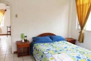 a bedroom with a bed with blue and yellow sheets at The Finch House (La Casa del Pinzón) in Puerto Ayora