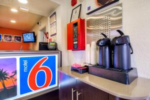 a restaurant with a gas station with a table with a tv at Motel 6-Chino, CA - Los Angeles Area in Chino