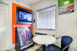 a room with a table and a tv on a wall at Motel 6-Chino, CA - Los Angeles Area in Chino