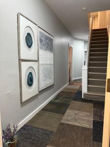 een gang met twee schilderijen aan de muur en een trap bij Eagle Pamir Guest House in New Haven