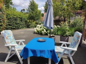 a table and two chairs and an umbrella at Gastenverblijf Op den dreef in Hamont +2 photos