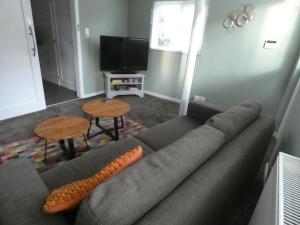 a living room with a couch and a flat screen tv at Gastenverblijf Op den dreef in Hamont