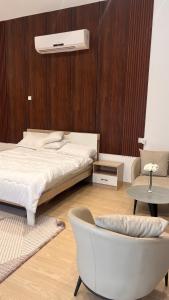 een slaapkamer met een bed en een stoel bij Riva chalet in Badīyah