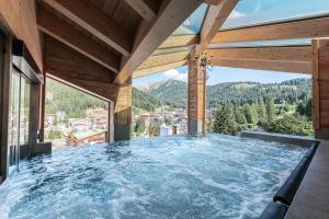 een groot dompelbad in een huis met uitzicht bij Cerana Relax Hotel in Madonna di Campiglio