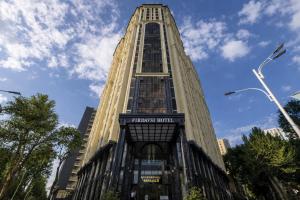 een hoog gebouw met een bord aan de zijkant bij Aram Hotel in Doesjanbe