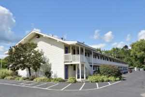 a large white building with a parking lot at Travelodge by Wyndham Brattleboro VT in Brattleboro