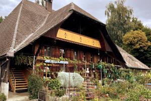 una grande casa con molte piante sopra di Familienferien in einem 200 Jahre alten Berner Bauernhaus 