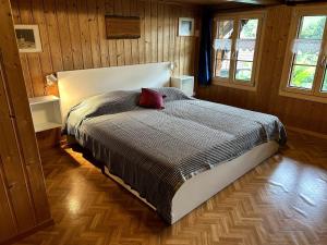 una camera da letto con un letto con un cuscino rosso sopra di Familienferien in einem 200 Jahre alten Berner Bauernhaus  Altre 15 foto