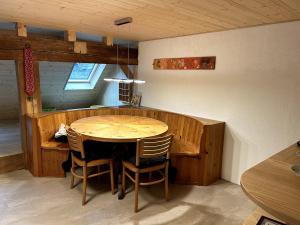 una sala da pranzo con tavolo e sedie in legno di Familienferien in einem 200 Jahre alten Berner Bauernhaus 