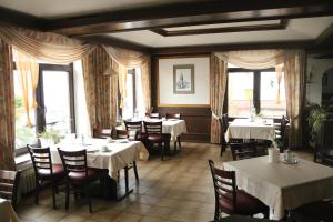 ein Esszimmer mit Tischen, Stühlen und Fenstern in der Unterkunft Hotel zur Struth in Eschwege