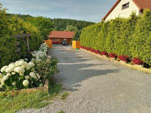 eine Auffahrt mit Blumen an der Seite eines Hauses in der Unterkunft Agroturystyka U Zosi Bałtów in Bałtów