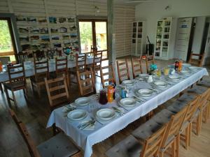 ein langer Tisch mit weißen Tellern darauf in einem Zimmer in der Unterkunft Agroturystyka U Zosi Bałtów in Bałtów