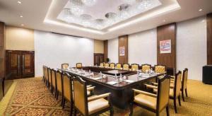 une grande salle de conférence avec une longue table et des chaises dans l'établissement Lhasa Hotel, à Lhasa
