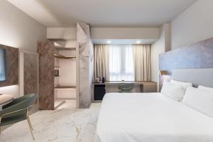 a bedroom with a large white bed and a desk at Baires Guest House in Milan