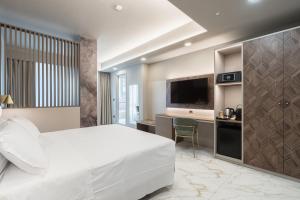 a hotel room with a white bed and a desk at Baires Guest House in Milan