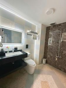 een badkamer met een toilet, een wastafel en een douche bij Eden Hotel in Ho Chi Minh-stad