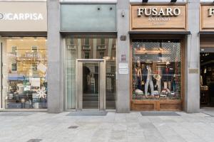 a store front with the doors open on a city street at Baires Guest House in Milan
