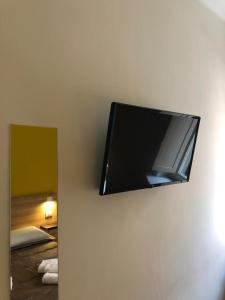 een flatscreen-tv die aan de muur hangt bij Il Piccolo Albergo Matera in Matera