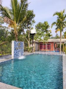 een zwembad met een fontein voor een huis bij Rainy Cloud Homestay Private Cottages -Pool, Estate, Near to Falls & Safari in Chikmagalūr